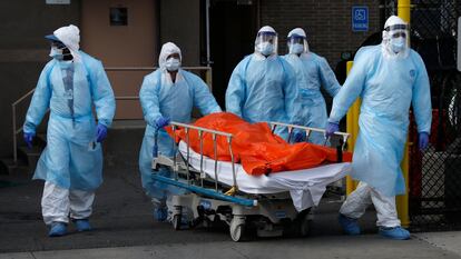 Un grupo de sanitarios trasladan a la morgue a un fallecido por coronavirus en Nueva York.