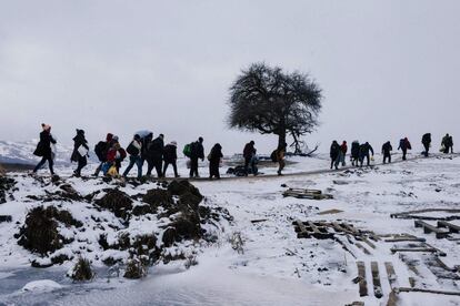 Un grupo de migrantes y refugiados caminan por los campos cubiertos de nieve, después de cruzar la frontera con Macedonia en Serbia cerca del pueblo de Miratovac.