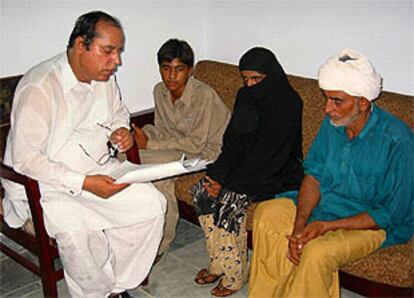 Mukhtar Mai, con su padre (derecha) y su hermano, recibe instrucciones de su abogado antes del juicio.