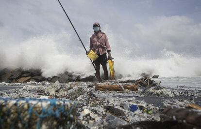 Un hombre intenta pescar en una playa de Kapungoda (Sri Lanka) contaminada por el vertido de un barco que se hundió debido a un incendio.