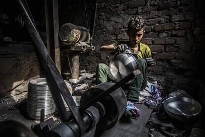 Aslam, 16 años. Trabaja torneando cacerolas de aluminio durante 11 horas los 365 días del año por unos 18 dólares al mes.