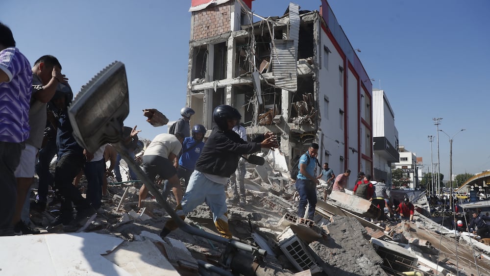 AME7645. CALI (COLOMBIA), 10/08/2026.- Personas caminan sobre los escombros de un edificio colapsado este lunes, en Cali (Colombia). Al menos 20 edificios sufrieron graves daños por consecuencia del terremoto de magnitud 7,4 que sacudió la mayor parte del país, con epicentro en la zona del Pacífico. EFE/ Ernesto Guzmán