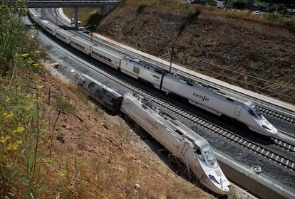 Los trenes de línea convencional circulan ya por una de las vías de tren afectadas por el accidente del pasado miércoles en las proximidades de la estación de Santiago de Compostela. En la imagen, un tren circula por la vía convencional que discurre paralela la del accidente.