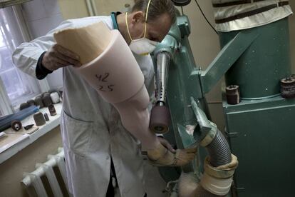 Un técnico da forma a una pierna ortopédica en los talleres que la clinica GmbH tiene en Kiev.