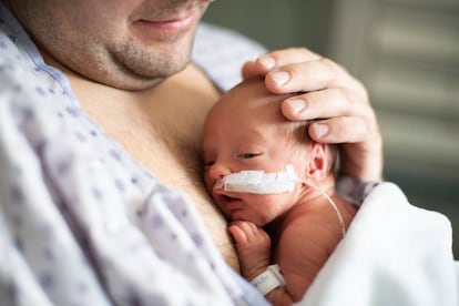 Un padre cuida de su bebé prematuro haciendo piel a la piel en el hospital.