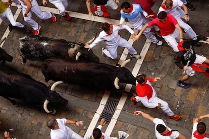 Varios corredores junto a los toros de la ganadería de Victorianos del Río, este martes en San Fermín. 