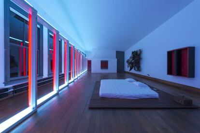 Dormitorio de Donald Judd en la quinta planta del edificio neoyorquino (en el número 101 de la calle Spring) que el artista compró en 1968; a la izquierda se ve la escultura fluorescente que Dan Flavin creó en 1970 para conmemorar el nacimiento de Flavin, uno de los hijos de Judd, y que recorre los 10 ventanales del espacio.