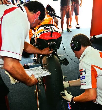 Dos mecánicos del equipo de Márquez comprueban la presión y la temperatura de las ruedas durante una de las series de entrenamiento.