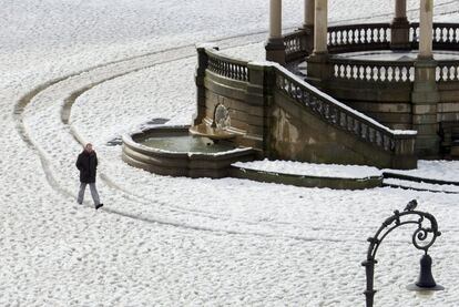 Un hombre camina por la Plaza del Castillo de Pamplona cubierta de nieve.