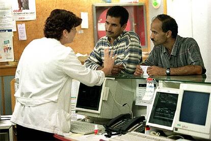 Una enfermera atiende a dos inmigrantes en un centro de salud.