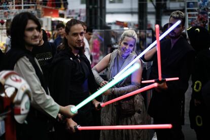 En la imagen, un grupo de cuatro jóvenes son retratados con unas espadas láser de la franquicia de películas estadounidense 'Star Wars'.