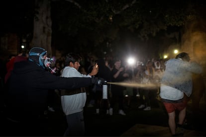 Un hombre lanza un químico a otro manifestante, en el campus de UCLA, este miércoles.