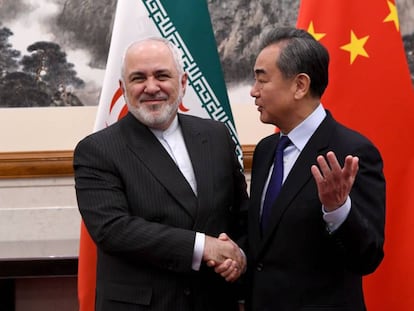 El ministro de Exteriores de China, Wang Yi (der.), habla con su homólogo iraní Mohammad Javad Zarif, el pasado 31 de diciembre.