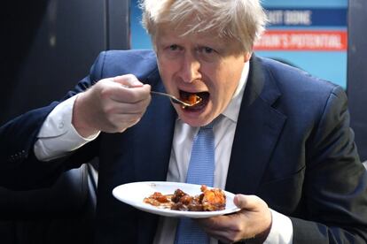 Johnson toma un trozo de tarta en su autobús de campaña después de visitar Red Olive, una empresa de comida preparada, este miércoles en Derby, Inglaterra.