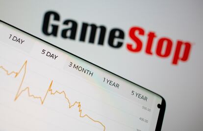 Gráfico de acciones de GameStop ante el logotipo de la empresa.