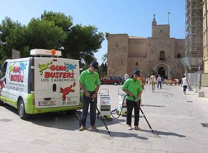 La brigada <i>cazachicles,</i> en Palma de Mallorca. Abajo, una operaria en pleno proceso de limpieza.