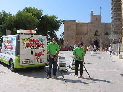 La brigada <i>cazachicles,</i> en Palma de Mallorca. Abajo, una operaria en pleno proceso de limpieza.