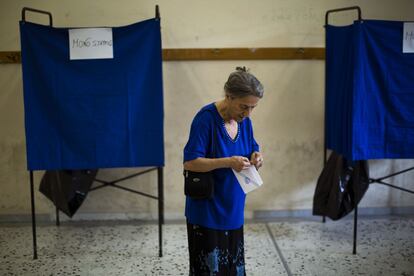 Una mujer sostiene su papeleta antes de proceder votar, este domingo, en un colegio electoral en Atenas.