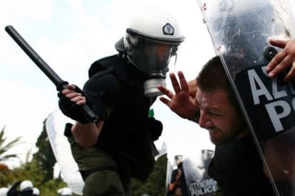Un policía carga contra un manifestante durante un enfrentamiento que se desató durante una protesta con motivo de una nueva huelga general por las calles del centro de Atenas.
