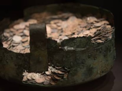 The restored cauldron and Roman coins.