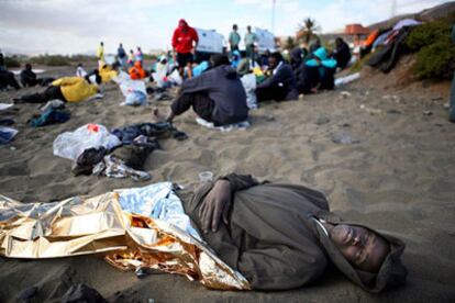 Uno de los inmigrantes llegados a la playa del Gran Tarajal yace exhausto tras su detención.
