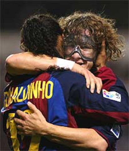 Puyol abraza a Ronaldinho tras marcar el brasileño uno de sus goles.