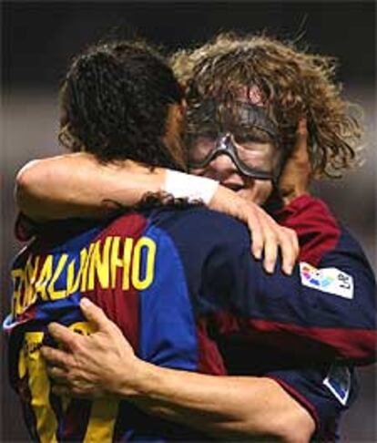 Puyol abraza a Ronaldinho tras marcar el brasileño uno de sus goles.