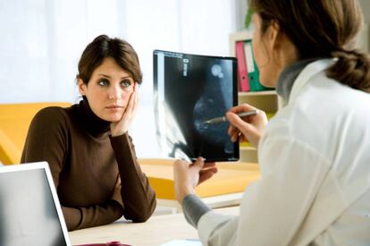 Doctora examina la mamografía de una paciente.