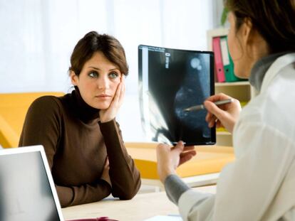 Doctora examina la mamografía de una paciente.