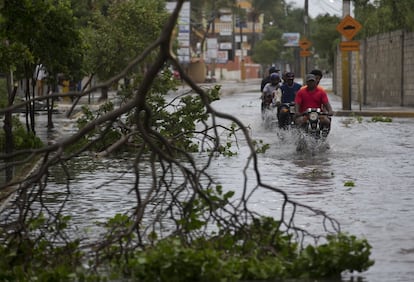 La República Dominicana, en alerta máxima, aceleró este jueves los preparativos para hacer frente a la amenaza del huracán María. En la imagen, varias personas transitan en vehículos por una calle inundada antes del paso del ciclón en Punta Cana, en el extremo oriental de la República Dominicana.