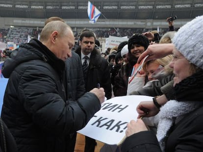 Putin da un aut&oacute;grafo durante un mitin electoral.