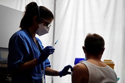 Una profesional sanitaria administra la vacuna a un ciudadano en los pasillos del Hotel SB Plaza Europa, en Hospitalet de Llobregat (Barcelona), el 11 de marzo.