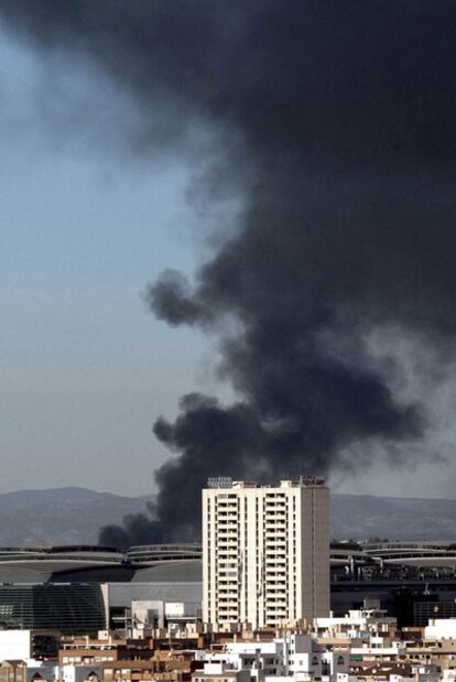 Columna de humo proveniente del incendio declarado en el polígono de Fuente del Jarro, en Paterna.