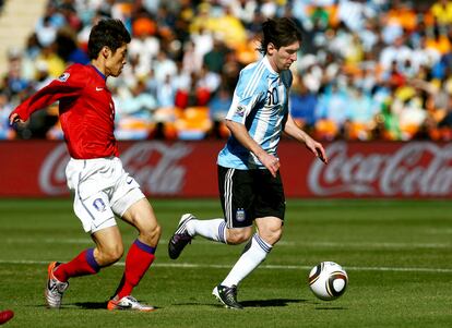 El coreano Park Ji-Sung intenta alcanzar a Lionel Messi.