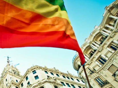 Una mujer ondea la bandera arcoiris en Madrid durante la celebración del Orgullo LGTBI+.
