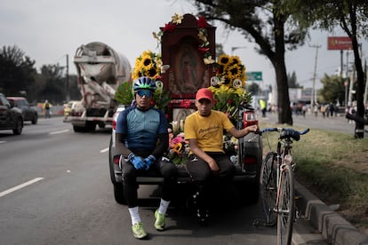 Un par de peregrinos que vienen desde Puebla en bicicleta descansan sentados en la camioneta de sus familiares.