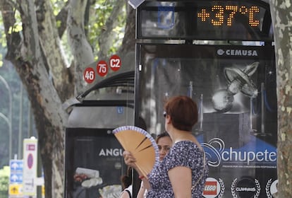 Una señora se abanica mientras espera al autobús. El termómetro de la parada indica los grados que alcanzaba esta mañana la capital: 37. Sanidad pide que se extremen las medidas de precaución en el caso de los colectivos más vulnerables como las personas mayores, los niños y los enfermos crónicos.