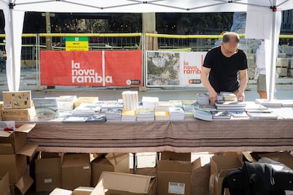 Un hombre prepara uno de los puestos en las Ramblas de Barcelona a primera hora.