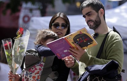 Una familia ojea un libro en un puesto del centro de Barcelona. 