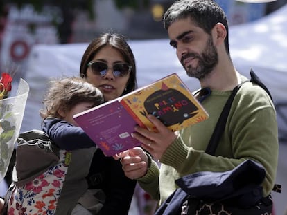 Una familia ojea un libro en un puesto del centro de Barcelona. 