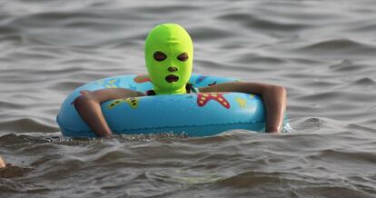 Una mujer utiliza el llamado 'facekini' para protegerse de la luz solar playa de Qingdao, una prenda cada vez más habitual en el paisaje de las costas chinas.