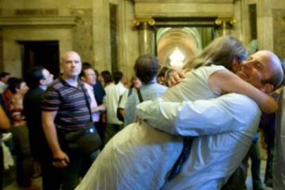 Dues persones s'abracen al Parlament després de la votació que prohibeix els toros.