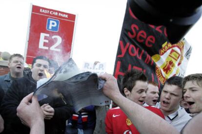 Seguidores del Manchester United protestan contra su venta a Malcolm Glazer junto al estadio de Old Trafford.