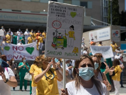Una trabajadora de limpieza del Hospital Gregorio Marañón sujeta una pancarta que reivindica la importancia de los servicios públicos en Sanidad, el 22 de junio.