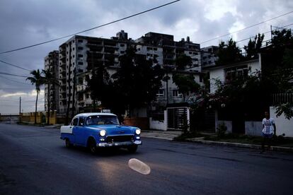 Un coche vintage pasa junto a un condón inflado en la calle de La Habana (Cuba).
