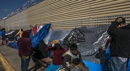 Um grupo de imigrantes aguarda em um acampamento improvisado diante do muro fronteiriço em San Luis Rio Colorado, no Estado de Sonora.