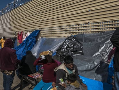 Um grupo de imigrantes aguarda em um acampamento improvisado diante do muro fronteiriço em San Luis Rio Colorado, no Estado de Sonora.