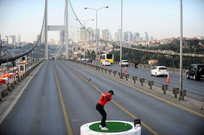 Estambul, Turquía, 5 de noviembre de 2013. Tiger Woods golpea una bola sobre una plataforma situada en un puente sobre el Bósforo en Estambul para promocionar el Torneo Abierto de Golf de la Aerolínea Turca.