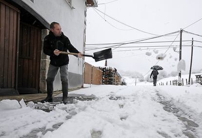 Una persona retira con una pala la nieve acumulada frente a su casa en Espinal, Navarra.