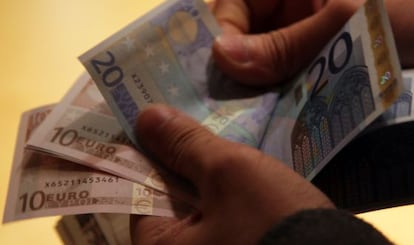 Un hombre cuenta billetes de euro en 2011.